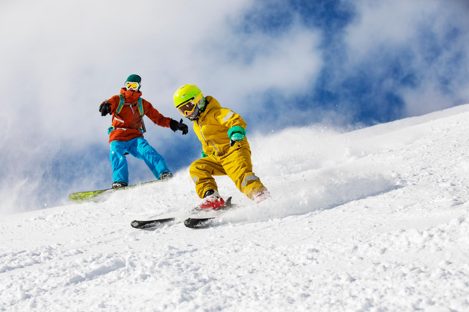 Father and son skiing down slope